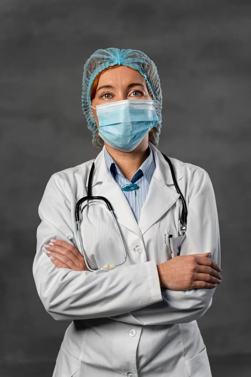 front view female doctor with medical mask hairnet posing with arms crossed